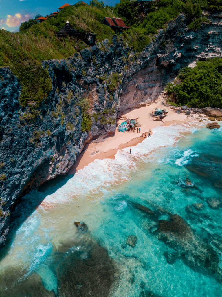 A breathtaking aerial view of the rocky cliffs and turquoise waters at Uluwatu Beach, Bali.